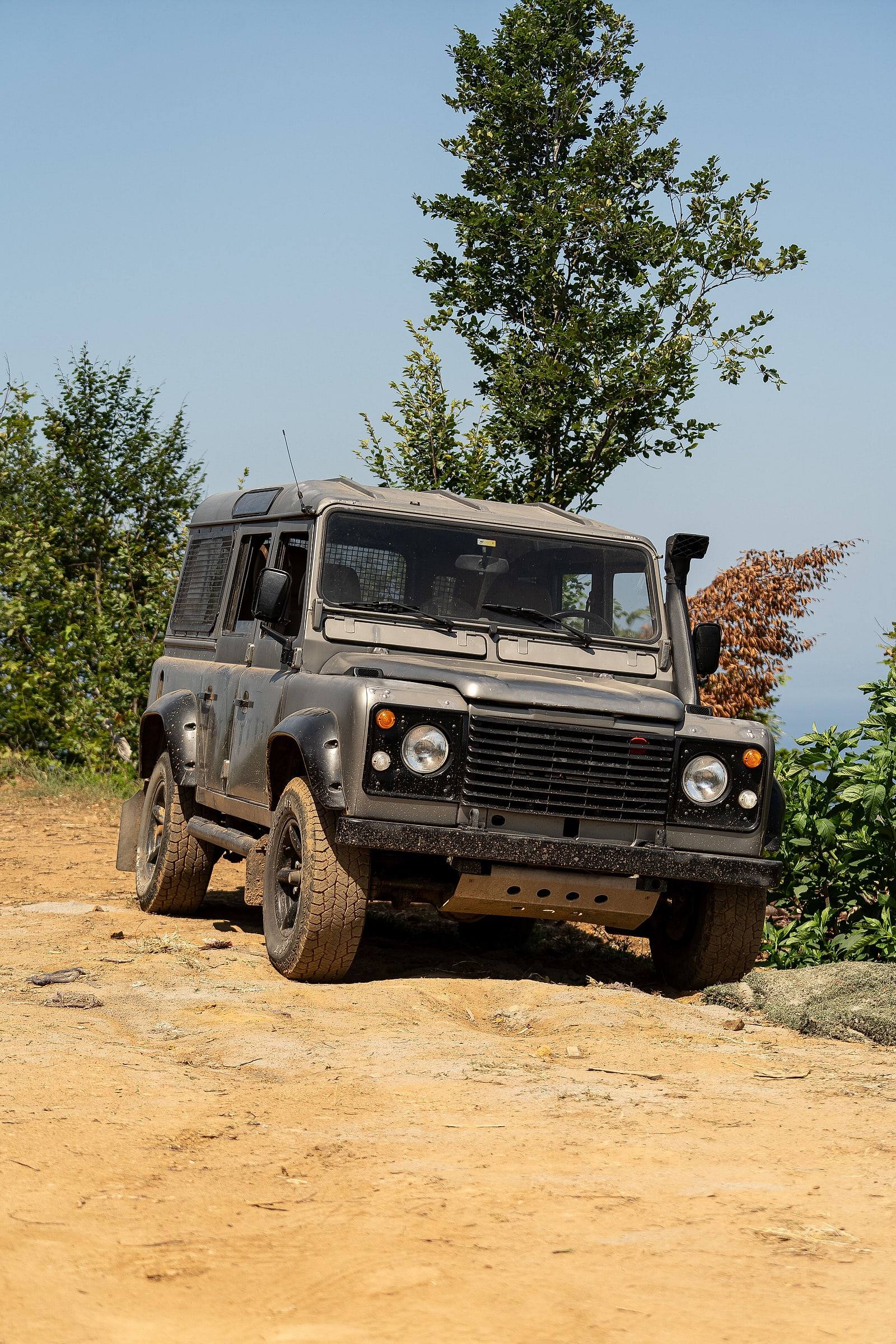Klassischer Land Rover Defender auf staubiger Piste